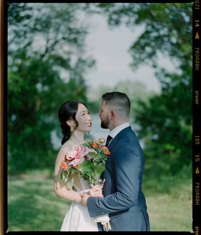 20240810-philadelphia-pennsylvania-wedding-couple-looking-into-each-others-eyes-with-river-and-tree-backdrop